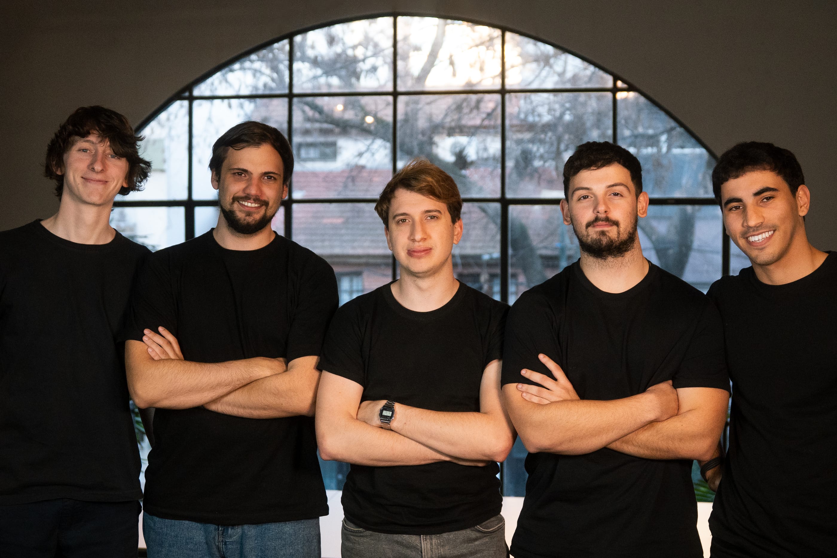 Los cinco fundadores de Loybox, de pie frente a un ventanal en arco de la oficina de Buenos Aires