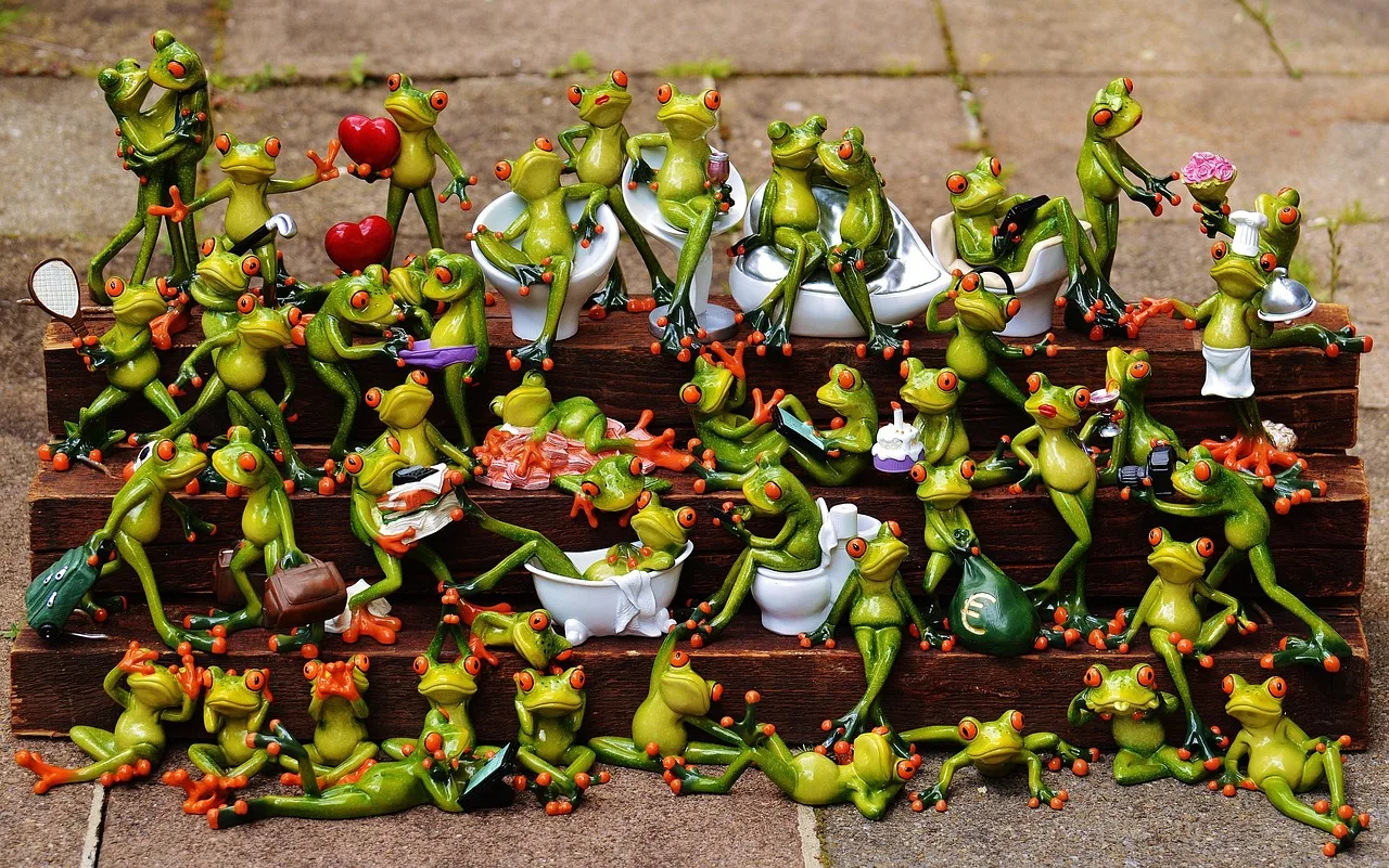 Decenas de figuritas de ranas de colores acomodadas en escalones de madera, cada una con su propio objeto